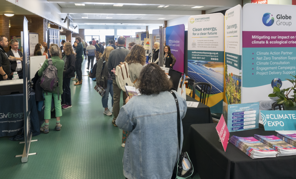 A shot of a busy room with lots of business stalls and people standing talking to each other