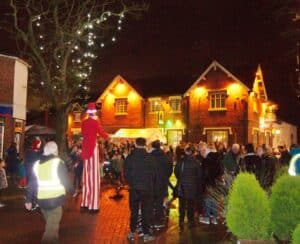 Night in a village with a man on stilts, a crown and christmas lights