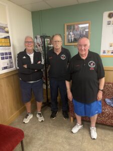 An image of three men standing together and smiling